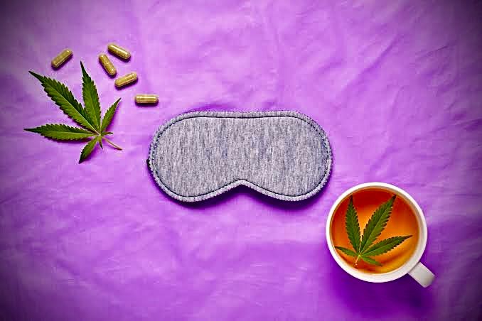 Cannabis vs. Sleep: CBD capsules, cannabis leaf, sleep mask, and tea on a purple background